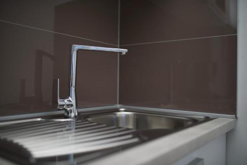 a sink with a faucet in a kitchen at Apartments and Rooms Jospino in Mali Lošinj