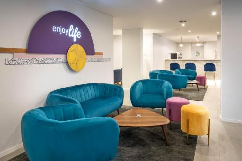 a waiting room with blue chairs and a table at Allegro Madeira - Adults Only in Funchal
