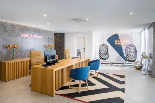 an office with a reception desk and blue chairs at Allegro Madeira - Adults Only in Funchal
