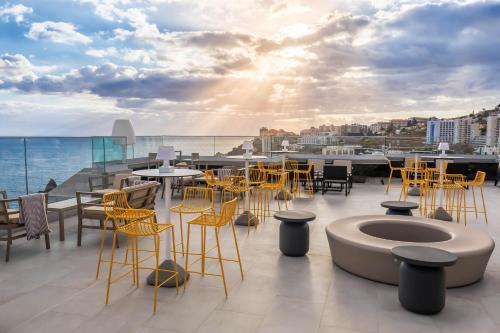 a rooftop patio with tables and chairs on a building at Allegro Madeira - Adults Only in Funchal
