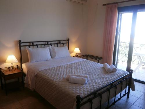 a bedroom with a bed with two towels on it at Flisvos Apartments in Megalochori