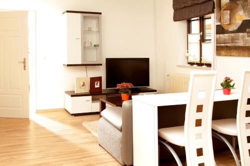 uma sala de estar com uma televisão e uma mesa e cadeiras em Ferienwohnung Am Turm em Bad Staffelstein