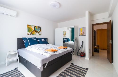 a bedroom with a large bed with blue pillows at Pop your C-O-L-O-R-S - Funky and Modern 1BDR. Apt. in Plovdiv