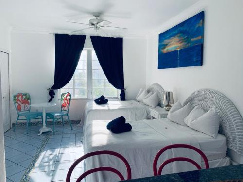 a bedroom with two beds and a table and chairs at Beachfront Ocean Dr white sand paradise SoBe 311 in Miami Beach