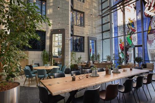 un restaurant avec des tables et des chaises dans un bâtiment dans l'établissement Hótel Reykjavík Grand, à Reykjavik