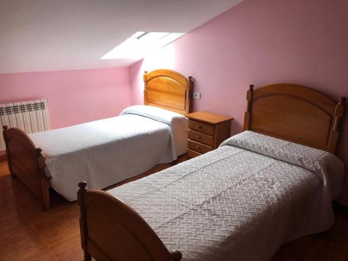 two beds in a room with pink walls at B&b o barqueiro 2 in O Barqueiro