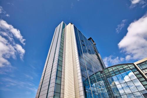 a tall glass building with a blue sky in the background at H&oacute;tel Reykjav&iacute;k Grand in Reykjav&iacute;k