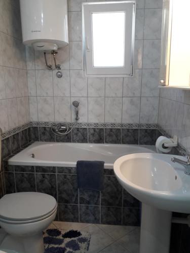 een badkamer met een bad, een toilet en een wastafel bij Apartment Jelena in Podstrana
