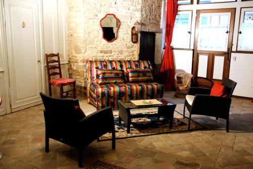 een woonkamer met een bank en stoelen bij Le Colimaçon in Cluny