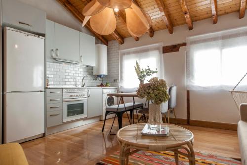 una cocina con armarios blancos y una mesa con flores. en Renovado Ático en Chamberí, en Madrid