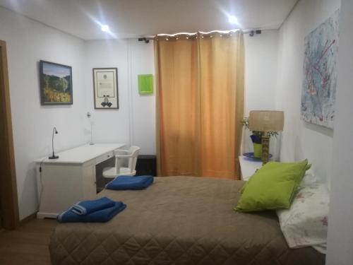 a bedroom with a bed with a desk and a computer at Isabel do Couto - casa de charme in Castro Daire