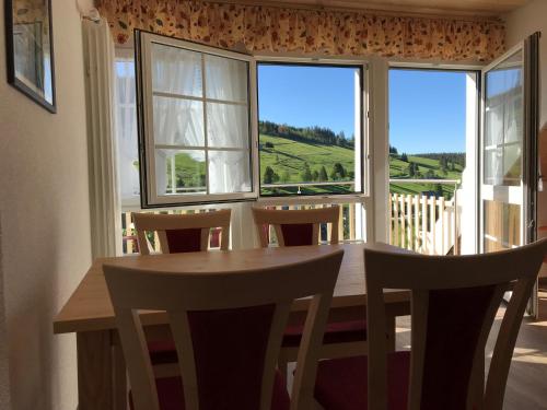 a dining room with a table and chairs and windows at Pension Glöcklehof in Todtnauberg