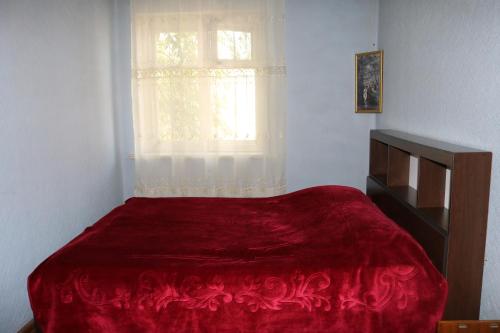 - une chambre avec un lit rouge et une fenêtre dans l'établissement Wine Garden Rabati, à Akhaltsikhé