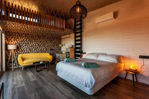 a bedroom with a bed and a yellow chair at Nidos de carnota in Carnota