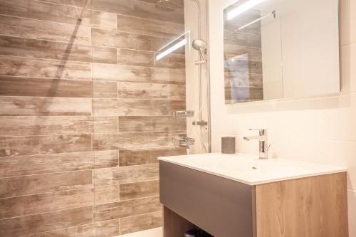 uma casa de banho com um lavatório e um espelho em PORTES DU PLENEY 001 em Morzine