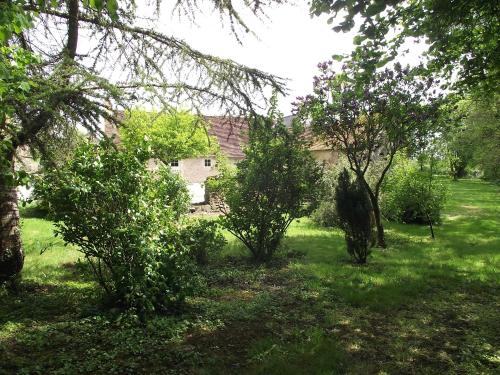 a yard with trees and a house in the background at Gite de Foulleray n 14 in Rouez