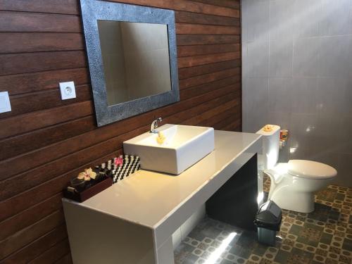 a bathroom with a sink and a toilet at Island Garden Huts Lembongan in Nusa Lembongan