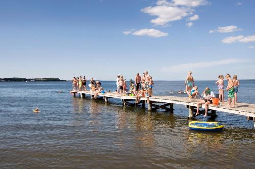 a group of people on the pier at the beach at Hvalpsund Færgekro in Hvalpsund
