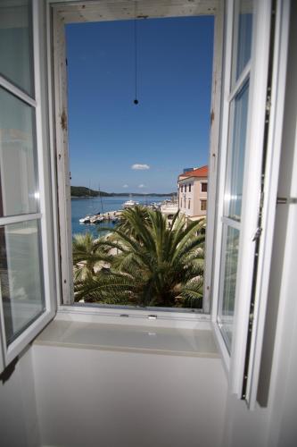 an open window with a view of the beach at Apartments and Rooms Jospino in Mali Lošinj
