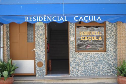 a building with a blue awning and a sign on it at Caçula, Alojamento Local in Torre de Moncorvo