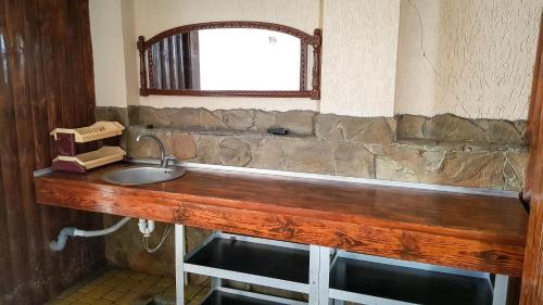 a bathroom with a wooden counter with a sink at мини-отель Травертин in Chornomorsk