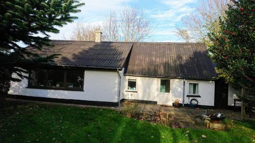 a white house with a black roof at B&B Hesselbjerg in Hesselbjerg
