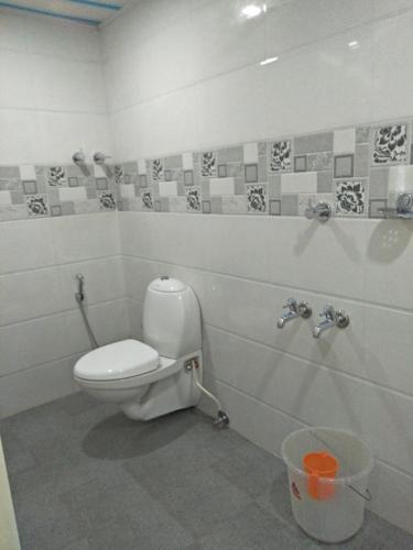 a bathroom with a toilet and a trash can at Ashoka Residency Chottanikkara in Chottanikara