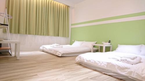 two beds in a room with green and white at NO.14 in Tainan