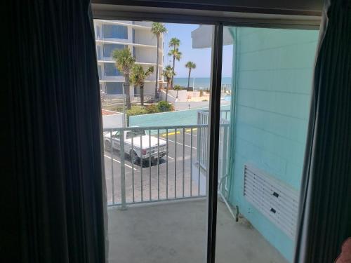 uma varanda com vista para uma piscina e um edifício em SeaScape Inn - Daytona Beach Shores em Daytona Beach