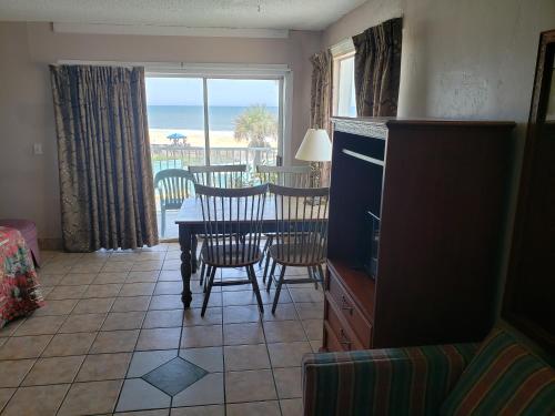 a dining room with a table and chairs and a view of the ocean at SeaScape Inn - Daytona Beach Shores in Daytona Beach