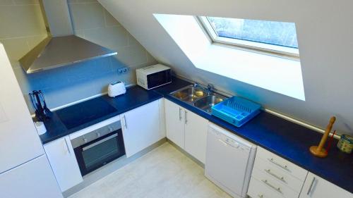 a small kitchen with a blue counter top and a window at Ático dúplex in La Massana