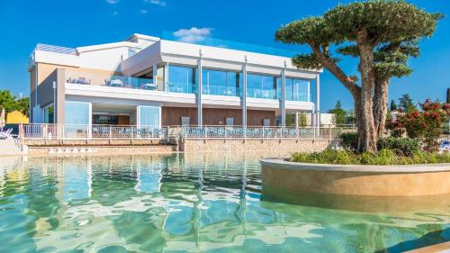 a villa with a swimming pool in front of a house at IdeaLazise Camping and Village in Lazise