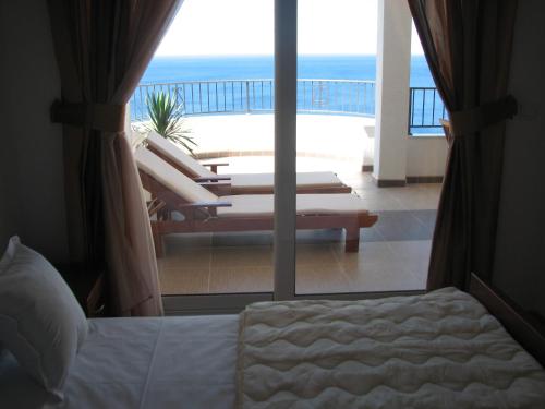 a bedroom with a view of the ocean from a balcony at Apartments Leut in Sveti Stefan