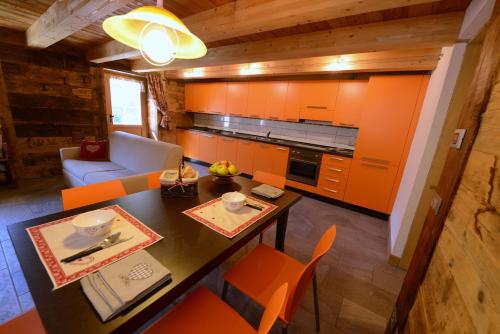 a kitchen with orange cabinets and a table and chairs at Vieilles Maisons D'Introd in Introd