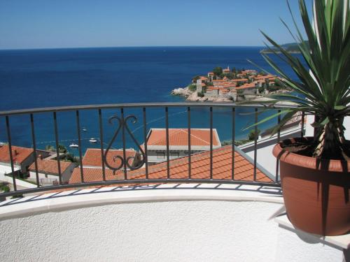 a balcony with a potted plant and the ocean at Apartments Leut in Sveti Stefan