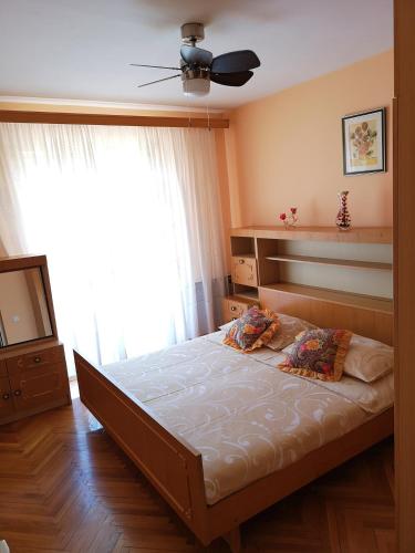 a bedroom with a bed and a large window at Naomi's Sunshine in Cres
