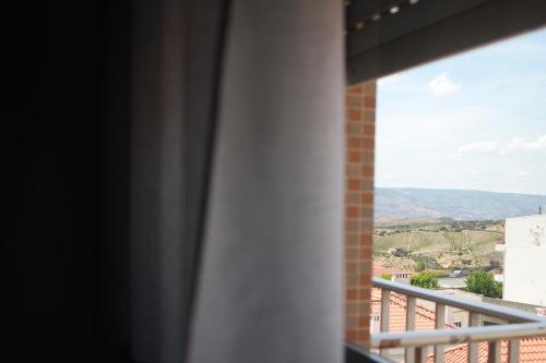 a window with a view of the countryside from a building at Caçula, Alojamento Local in Torre de Moncorvo