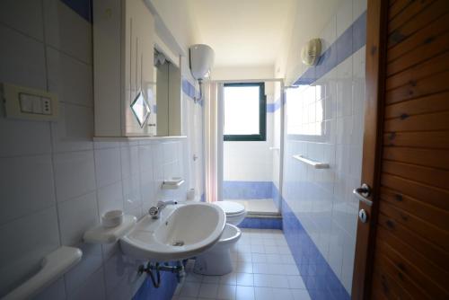 bagno bianco con lavandino e servizi igienici di Villaggio Sa Ventana a Badesi