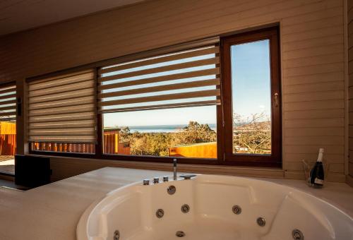 a bath tub in a bathroom with a window at Nidos de carnota in Carnota