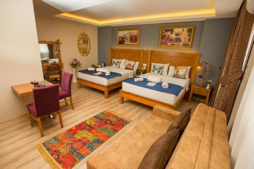 una habitación de hotel con dos camas y un sofá en The PeraPort Hotel, en Estambul