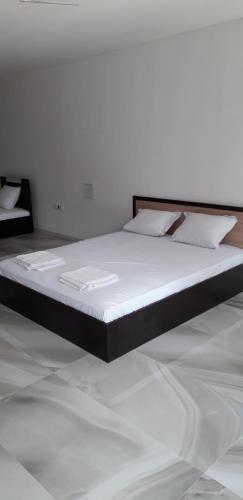 ソゾポルにあるZdravko Guest Houseの白い壁の客室の大型ベッド1台