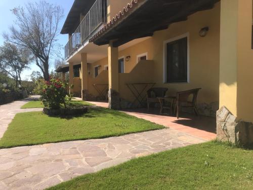 a patio outside of a house with grass and flowers at Hotel Belvedere in Teulada