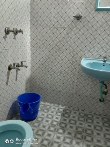 a bathroom with a blue sink and a blue bucket at Taj Mahal Hotel in Cochin