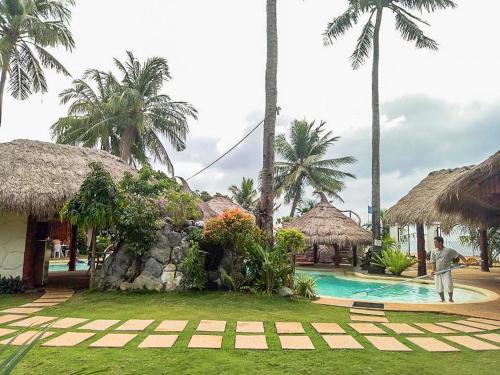 a man standing in front of a resort with a swimming pool at Camaya-an Paradise Beach Resort in Malabugas