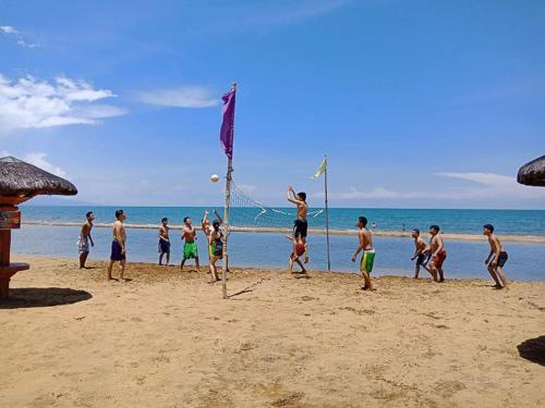 a group of children playing volley ball on the beach at Camaya-an Paradise Beach Resort in Malabugas
