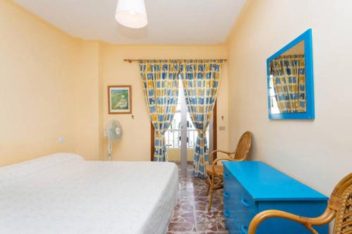ロス・クリスティアーノスにあるFirst Line Ocean Los Cristianosのベッドルーム1室(ベッド1台、青いテーブル、窓付)