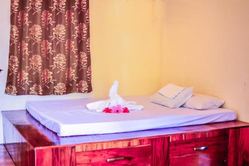 a bed with white sheets and flowers on it at Camaya-an Paradise Beach Resort in Malabugas