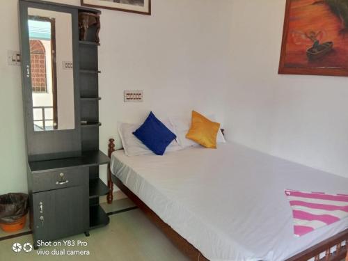 a small bedroom with a bed and a mirror at Taj Mahal Hotel in Cochin