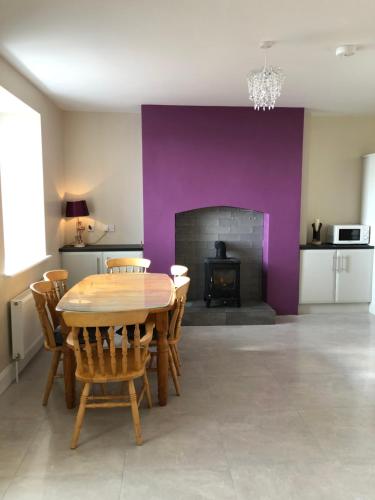 a dining room with a table and a fireplace at Skellig View House in Waterville