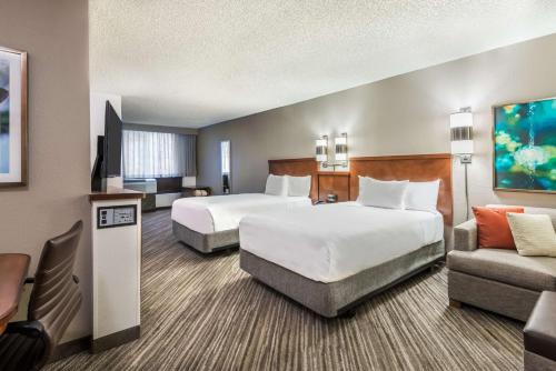 a hotel room with two beds and a couch at Hyatt Place Atlanta Duluth Johns Creek in Johns Creek